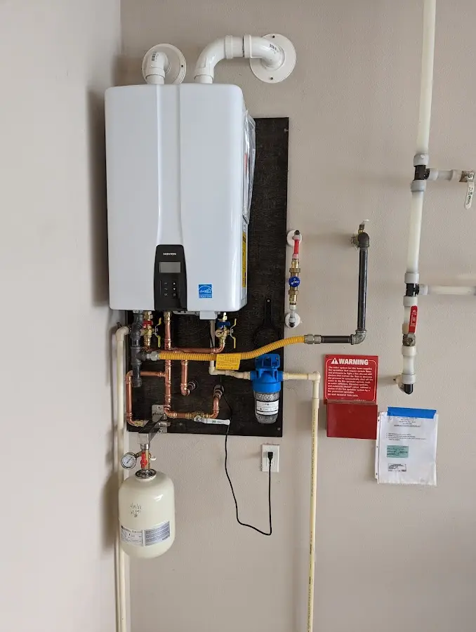 Professional plumber installing copper piping in a North Brookfield home